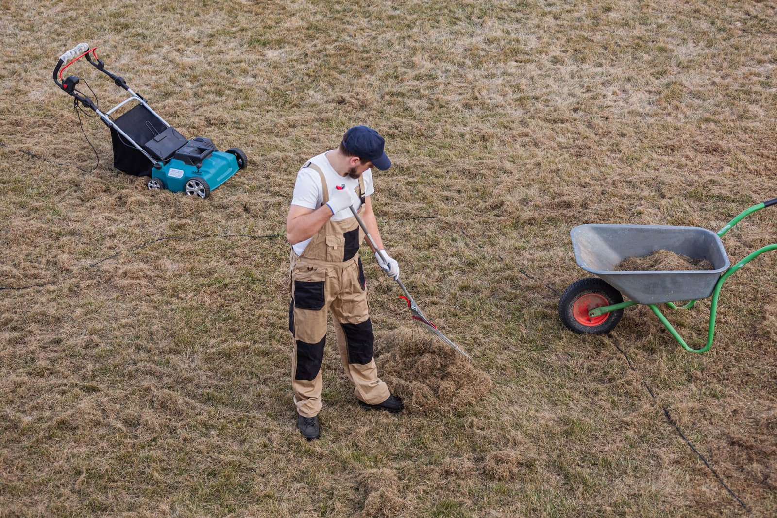 scarifying-lawn-with-rake-scarifier-man-gardener-scarifies-lawn-removal-old-grass-min-scaled.jpg